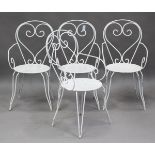 A set of four mid-20th century white painted wrought iron garden chairs with pierced circular seats,