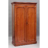 A Victorian mahogany wardrobe, the two panelled doors enclosing hanging space, sliding trays and