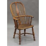 A mid-19th century yew and elm hoop back Windsor armchair, the shaped splat and stick back above a