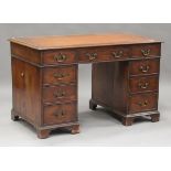 An early 20th century George III style mahogany pedestal desk, the moulded top inset with tooled