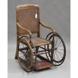 An early 20th century stained beech framed invalid's armchair with caned seat and back, height