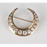A gold and diamond brooch, designed as a crescent, mounted with a row of cushion cut and rose cut