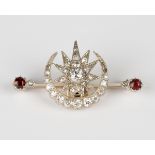 A gold backed and silver set, diamond and garnet brooch, designed as a crescent enclosing a