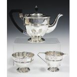 A George V silver three-piece tea set of circular form, comprising teapot, milk jug and sugar