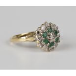 An 18ct gold, diamond and emerald hexagonal cluster ring, claw set with the principal circular cut