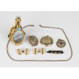 A mauve paste and imitation pearl pendant, a circular pendant locket, a gilt metal posy holder, a