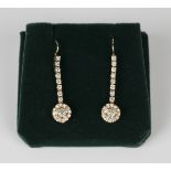 A pair of gold and diamond pendant cluster earrings, each cluster drop mounted with the principal