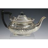 An Edwardian silver teapot of half-reeded cushion form, Birmingham 1904 by Heath & Middleton, length