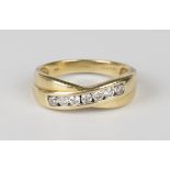 An 18ct gold and diamond ring, mounted with a row of seven circular cut diamonds in a twist