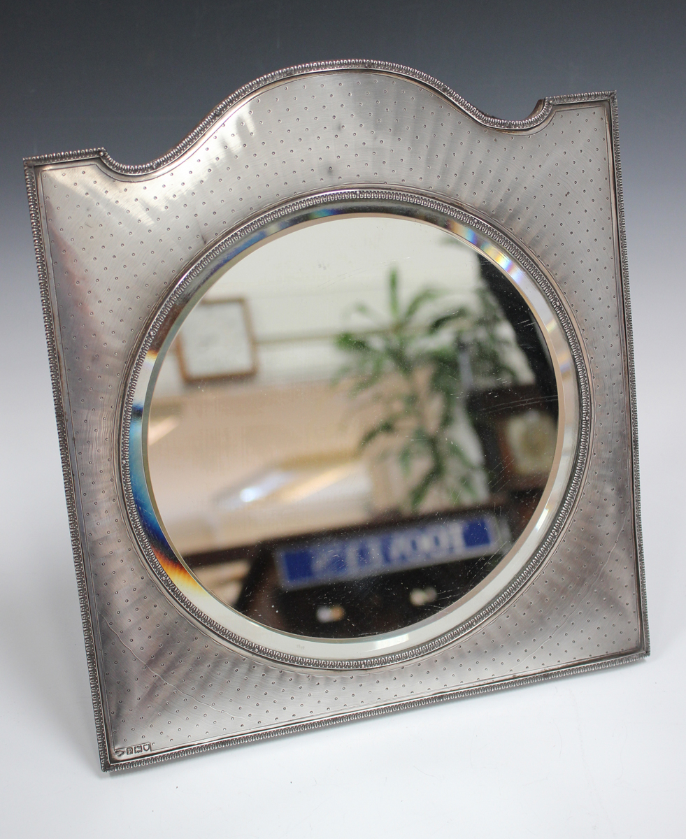 A George V silver framed dressing table mirror with arched top and engine turned decoration, oak