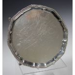 A George VI silver card salver with gadrooned rim, on scroll legs and hoof feet, London 1950 by