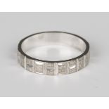 An 18ct white gold wedding band with faceted decoration and textured finish, London 1976, ring