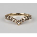 A 9ct gold and diamond ring in a wishbone shaped design, mounted with a row of eleven circular cut