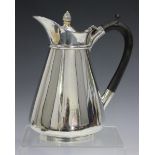 An Edwardian silver hot water pot of low-bellied tapering form with hinged lid, Birmingham 1906 by