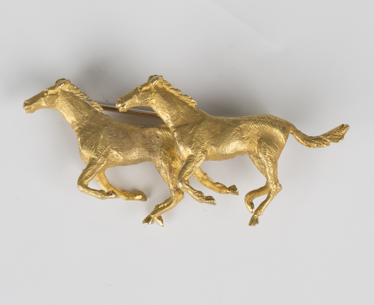 A 9ct gold brooch, designed as two galloping horses, with a textured finish, width 5.5cm, with an