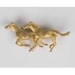 A 9ct gold brooch, designed as two galloping horses, with a textured finish, width 5.5cm, with an