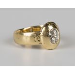 A gold and diamond single stone ring, mounted with an oval cushion cut diamond, the shoulders with