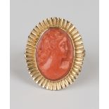 A gold and coral oval cameo ring, carved as a portrait of a lady within a radiating surround, ring