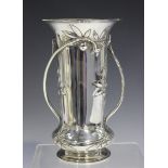 An Edwardian Arts and Crafts style silver trumpet vase, decorated in relief with leaves and berries,