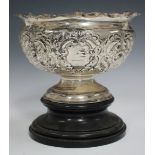 An Edwardian silver rose bowl with embossed flowers and foliate scrolls, on a circular pedestal