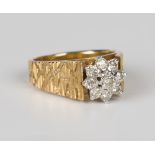 A gold and diamond nine stone cluster ring, mounted with circular cut diamonds between textured