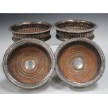A set of four George III silver wine coasters, each with flared rim and reeded sides above a