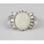 A white gold ring, claw set with an oval opal between baguette diamond set five stone fanned