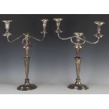 A pair of Edwardian plated on copper three-light candelabra, each with urn shaped sconces and