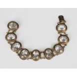 A Victorian gold and rock crystal bracelet, designed as a row of nine graduated oval cut rock