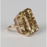 A gold ring, claw set with a large cut cornered rectangular step cut citrine, the setting pierced