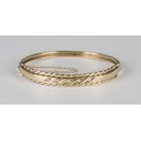 A 9ct gold and diamond oval hinged bangle, mounted with a row of five circular cut diamonds within