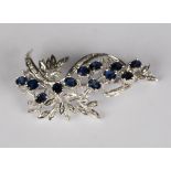 A diamond and sapphire brooch, designed as a floral spray, length 5.6cm.Buyer’s Premium 29.4% (