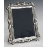 A modern silver photograph frame with scroll surround, Sheffield 1986, height 19cm.Buyer’s Premium