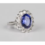 An 18ct white gold, tanzanite and diamond oval cluster ring, claw set with an oval cut tanzanite