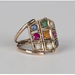 A gold and vari-coloured gem set nine stone ring of curved panel shaped form, the gems including