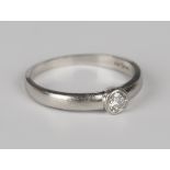 A platinum and diamond single stone ring, collet set with a circular cut diamond, ring size approx