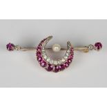 A gold, diamond, ruby and pearl brooch, designed as a crescent on a bar, the crescent mounted with a