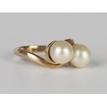 A gold ring, mounted with two cultured pearls in a crossover design, detailed '9ct', ring size