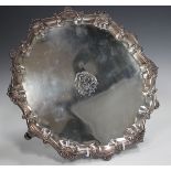 A George II silver salver with cast scalloped and scroll rim, framing a later engraved monogram to