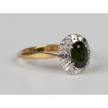 A gold, green tourmaline and diamond oval cluster ring, claw set with the oval cut green