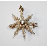 A gold, diamond and seed pearl pendant brooch, designed as an eight pointed star, mounted with a