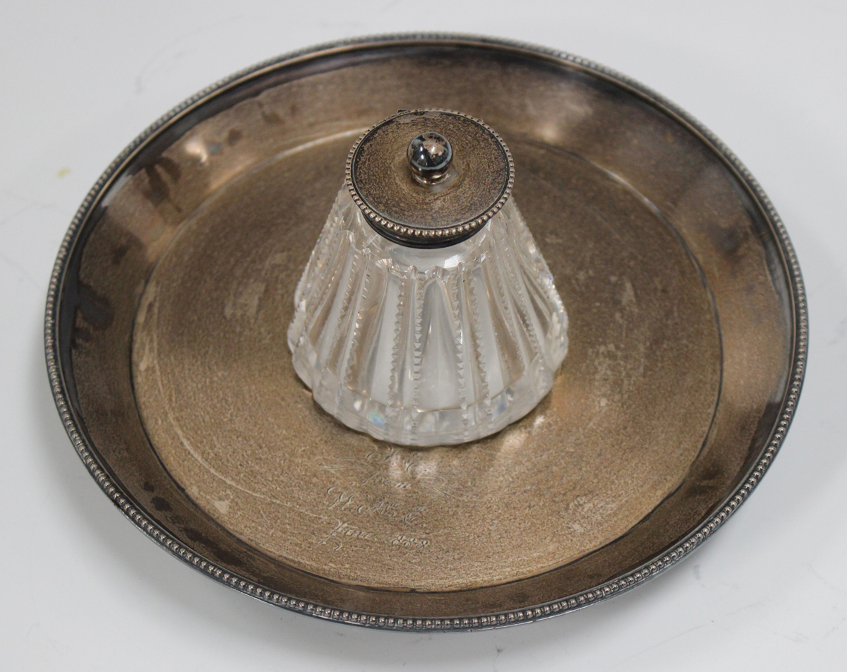 A Victorian silver circular inkstand, the cut glass inkwell with silver collar and beaded hinged