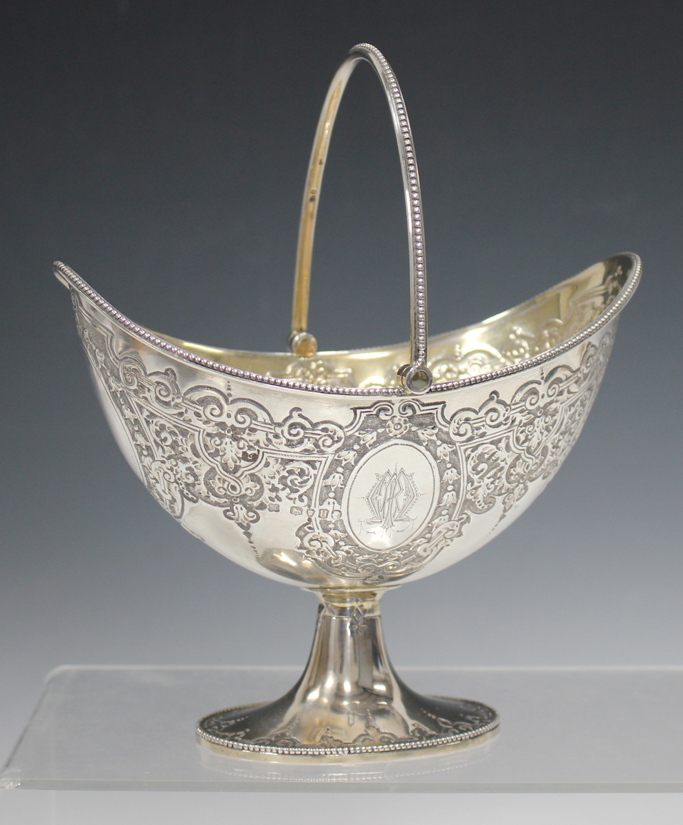 A Victorian silver oval bonbon basket, decorated with foliate scrolls and oval cartouches, with