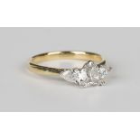 An 18ct gold and diamond ring, claw set with a heart shaped diamond between two pear shaped