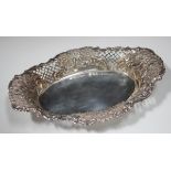 A late Victorian silver oval dish, embossed and pierced with a border of flowers and scrolls,