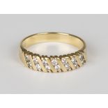 A gold and diamond ring, mounted with seven pairs of circular cut diamonds in a slanting design,