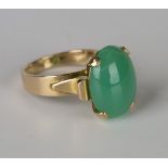 A gold and pale green agate single stone ring, claw set with an oval cabochon pale green agate,