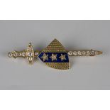 A gold, diamond set and blue enamelled brooch, designed as a sword and shield, length 4.7cm.Buyer’