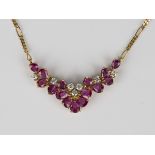 A gold, ruby and diamond necklace, the front mounted with seven circular cut diamonds and