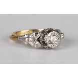 A gold, platinum and diamond single stone ring, mounted with a circular cut diamond between